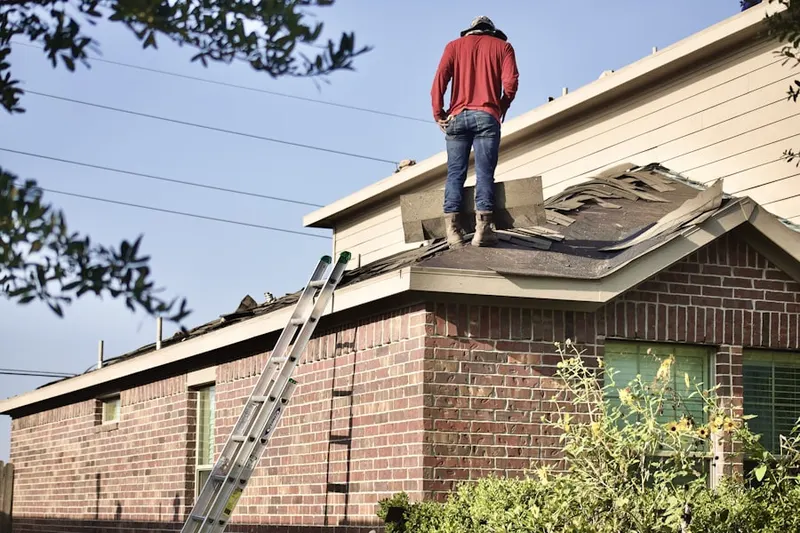 Professional roofer working on a residential roof in Six Corners